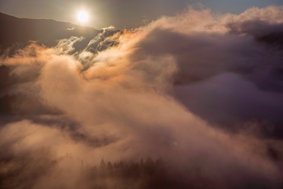 The morning sun breaking through swirling clouds
