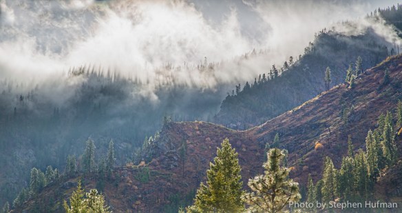 Sun light through mountain clouds highlighting cascading ridges