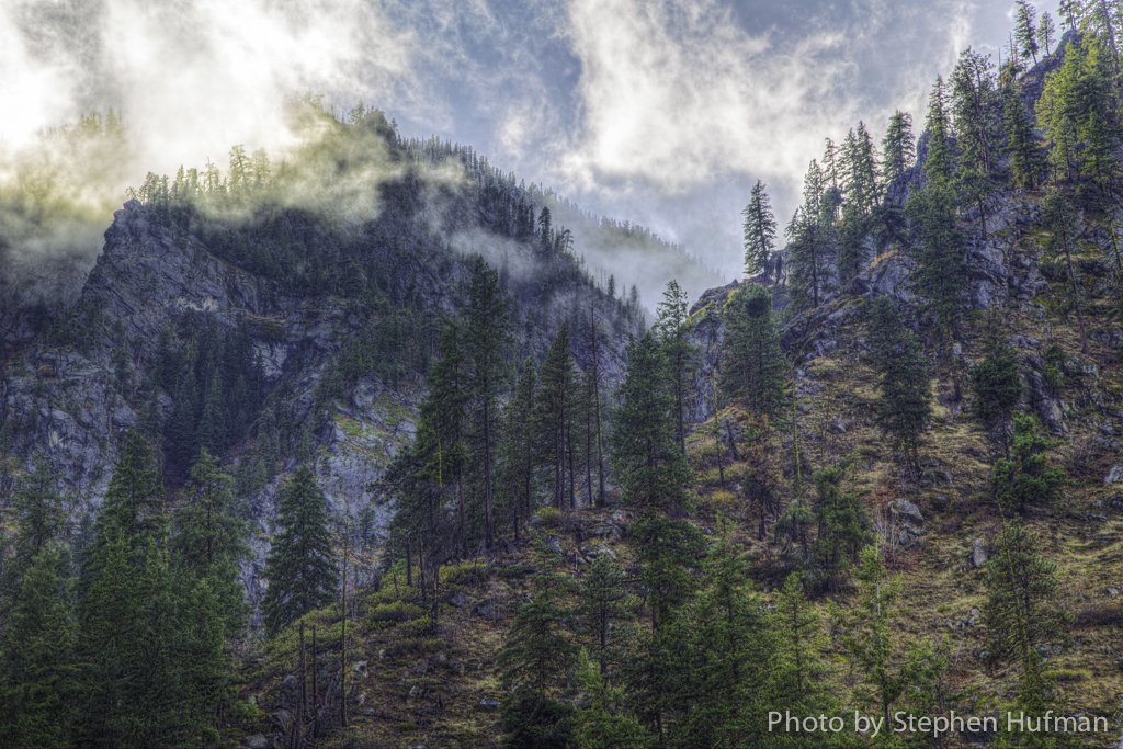 Sun lifting the clouds on the mountain peaks